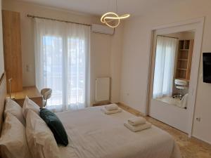 una camera da letto con un grande letto bianco con asciugamani di Luxury Suite Patras (1) a Patra