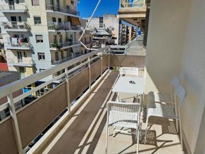 - Balcón con mesa, sillas y edificios en Luxury Suite Patras (1), en Patra