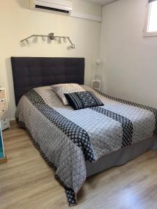 a bedroom with a bed with a black and white comforter at appartement atypique en duplex in Palavas-les-Flots