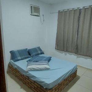 a bed with blue pillows in a room with a window at Casa com picina in São José da Coroa Grande +5 photos