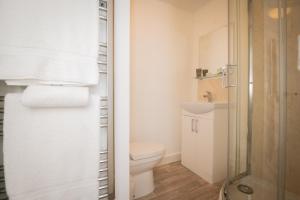 La salle de bains blanche est pourvue d'une douche et de toilettes. dans l'établissement Self containted 1 Bed modern apartment- Meters from Beach, à Great Yarmouth