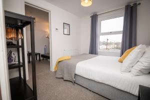 um quarto com uma cama grande e uma janela em Self containted 1 Bed modern apartment- Meters from Beach em Great Yarmouth