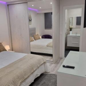 ein Schlafzimmer mit 2 Betten und ein Badezimmer mit einem Spiegel in der Unterkunft Soho Boutique Tioda, Totalmente reformado junto a las estaciones, WIFI in Oviedo