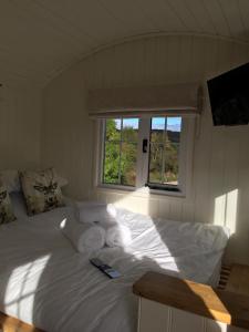 a white bed in a room with two windows at Foresterseat in Forfar