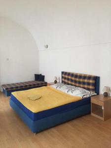 ein Schlafzimmer mit einem blauen Bett und einem Sofa in der Unterkunft Apartamento City in Košice
