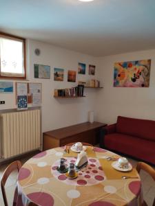ein Wohnzimmer mit einem Tisch und einem roten Sofa in der Unterkunft B&B Mattia in Civitanova Marche