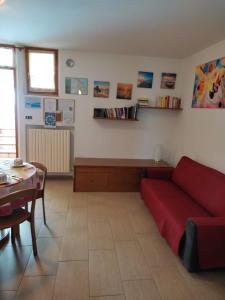 ein Wohnzimmer mit einem roten Sofa und einem Tisch in der Unterkunft B&B Mattia in Civitanova Marche