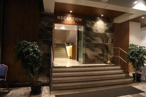 un vestíbulo de un hotel con escaleras que conducen a una recepción en Maple Inn en Thane