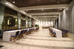 a row of tables and chairs in a room at Maple Inn in Thane