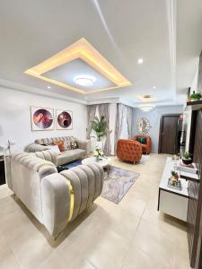 uma sala de estar com um sofá e uma mesa em Bee-City Homes em Abuja