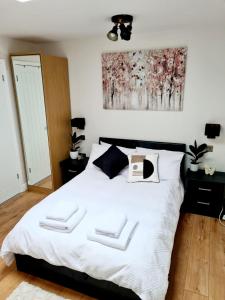 a bedroom with a bed with two white towels on it at Canterbury romantic modern home in Goodnestone
