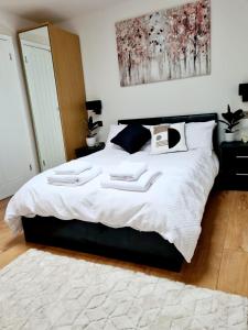 a bedroom with a large bed with two towels on it at Canterbury romantic modern home in Goodnestone