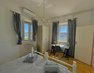 Seafront apartment with amazing view في يزيرا: غرفة نوم بسرير ومكتب ونوافذ
