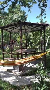 un refugio de picnic con una mesa y un banco en Cozy cottage near Tbilisi, en Kubriantkari