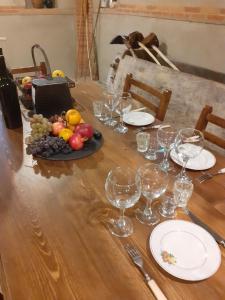 una mesa con copas de vino y un plato de fruta en Cozy cottage near Tbilisi, en Kubriantkari
