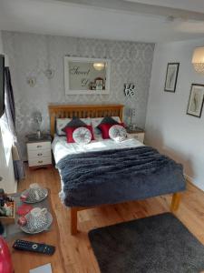 Un dormitorio con una cama con almohadas rojas. en Broadlea of Robgill Country Cottage & Bed and Breakfast, en Ecclefechan