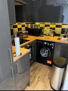 a kitchen with a washing machine and a sink at Modern flat in Maidstone in Kent