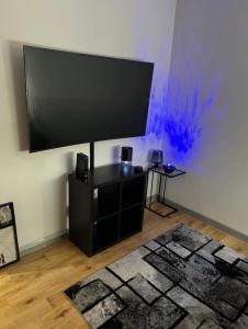 a large flat screen tv on a wall with a rug at Modern flat in Maidstone in Kent