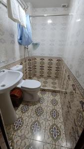 La salle de bains est pourvue de toilettes et d'un lavabo. dans l'établissement Aminabonu Hotel, à Samarcande