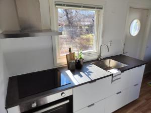 a white kitchen with a sink and a window at Strandskatan 102 in Halmstad