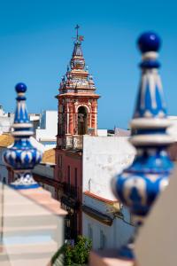 un edificio con una torre con una cruz encima en Casa Triana 1888 Suites by Época, en Sevilla