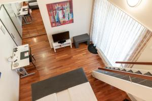 een woonkamer met een trap en een televisie bij Hotel Sursee in Sursee