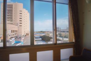 a view of a city from a window at Hostel and Cafe izu-no-umi in Atami