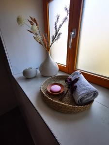ein Fensterbrett mit einer Schüssel mit einem Handtuch und einer Vase in der Unterkunft Haselnuss in Ilsenburg