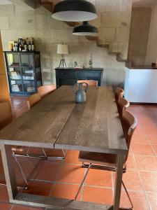 巴揚的住宿－Casa Catita - Douro，厨房里设有一张木桌,周围摆放着椅子