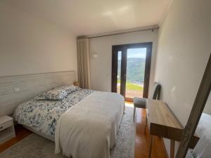 a bedroom with a bed and a large window at Casa Catita - Douro in Baião
