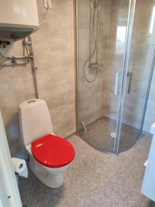 a bathroom with a red toilet and a shower at Strandskatan 102 in Halmstad