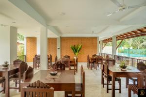 a restaurant with tables and chairs and a balcony at Anura's Elephant in Beruwala
