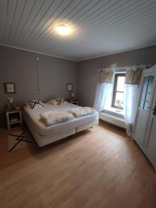 1 dormitorio con cama blanca y ventana en Le Floyon (avec piscine), en Florennes