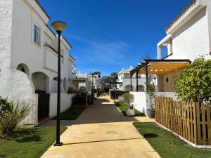 une rue avec des maisons blanches et un éclairage de rue dans l'établissement CASA PARAISO DEL SUR - Gran casa independiente de Lujo con amplias terrazas, à Costa Ballena