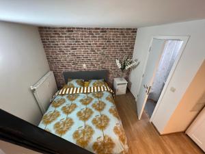 a bedroom with a bed and a brick wall at Design europarlament apartment with private terrace in Brussels