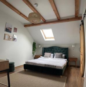 a bedroom with a large bed with a green headboard at Vila Aldor in Bran