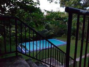 a view of a swimming pool through a fence at Chitra Ayurveda in Bentota