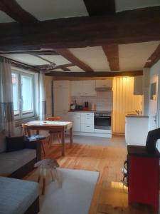 ein Wohnzimmer mit einem Tisch und einer Küche in der Unterkunft Fachwerk zum Entspannen, max. 3P in Bad Emstal