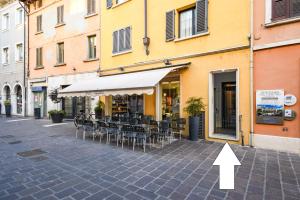 een pijl wijst naar een restaurant met tafels en stoelen bij DesenzanoLoft Blue lake star in Desenzano del Garda