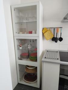 House Experience Villa Violeta في La Victoria de Acentejo: خزانة بيضاء مع الأطباق والأطباق فيها في مطبخ
