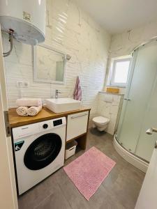 uma casa de banho com uma máquina de lavar roupa e um lavatório em Apartment Sanja em Zadar