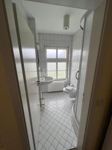 a bathroom with a tub and a toilet and a window at Spreewaldhotel Leipe in Leipe