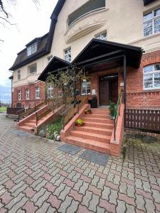 a brick house with stairs leading to the front door at Spreewaldhotel Leipe in Leipe