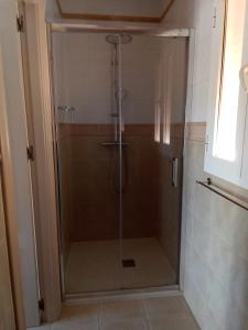 a shower with a glass door in a bathroom at Casa LIMA in Viñuela