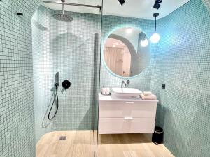 La salle de bains est pourvue d'une douche, d'un lavabo et d'un miroir. dans l'établissement Les 3 arches - Grenoble, à Grenoble