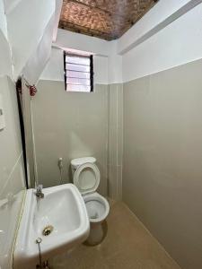 a bathroom with a sink and a toilet at Lorenza 2 and 3 in Buruanga