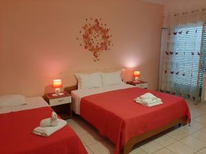 阿格里真托的住宿－terre di girgenti，一间卧室配有两张带红色床单和毛巾的床。
