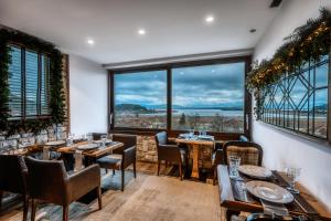 um restaurante com mesas e cadeiras e janelas grandes em MONTANA LAKE VIEW em Ioannina