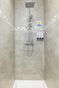 a shower with a shower head in a bathroom at Hillcrest Studio Apartments in Cleethorpes