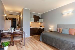 a bedroom with a bed and a desk and a kitchen at VacationClub - Bryza 7 Apartament 5 in Świnoujście